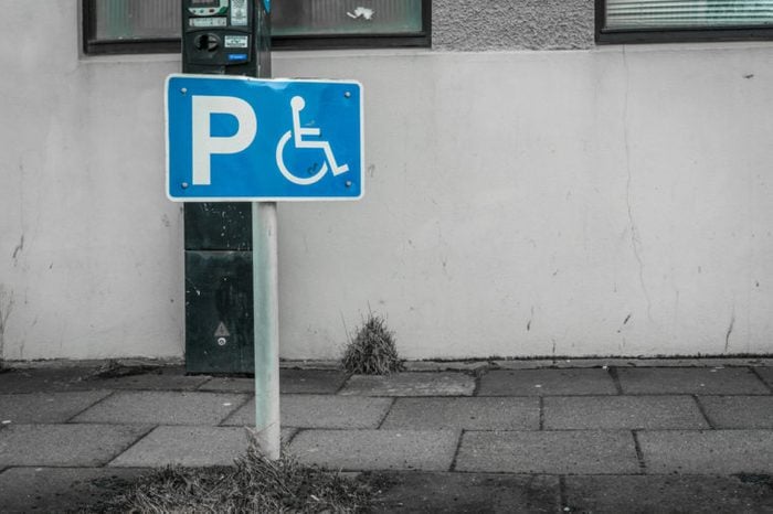 Handicap parking sign on a street in front of a building