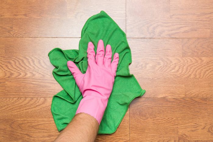 Wooden floors cleaning with rag in the room. Regular clean up. Maid cleans house.