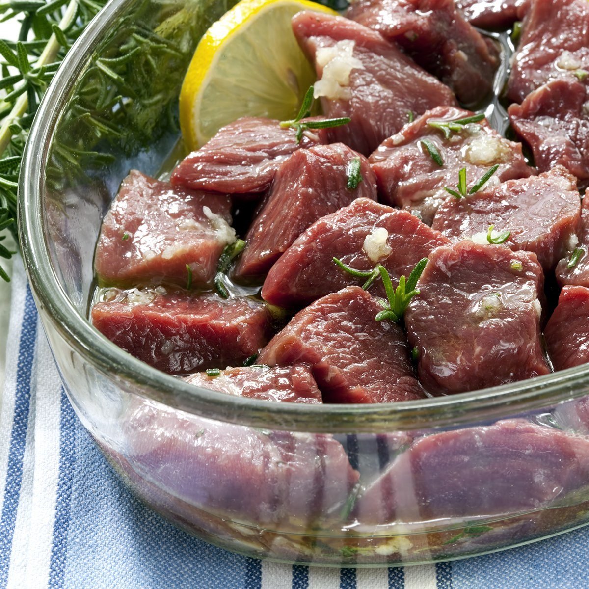 Lamb cubes, marinating in olive oil with garlic, rosemary and lemon.