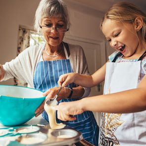 Little girl learning to make cup cakes with her grandmother. Excited girl pouring cake batter in cup cake moulds.; Shutterstock ID 1476944876; Job (TFH, TOH, RD, BNB, CWM, CM): TOH