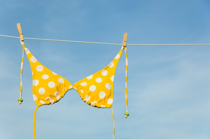 An itsy-bitsy teeny weeny yellow polka dot bikini hanging on a clothesline with copy space