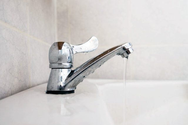 Close up dripping water drop of faucet in the bathroom , save water concept