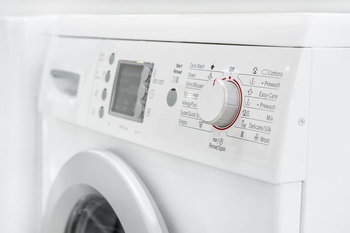 closeup of new white laundry or washing machine, selective focus on control elements