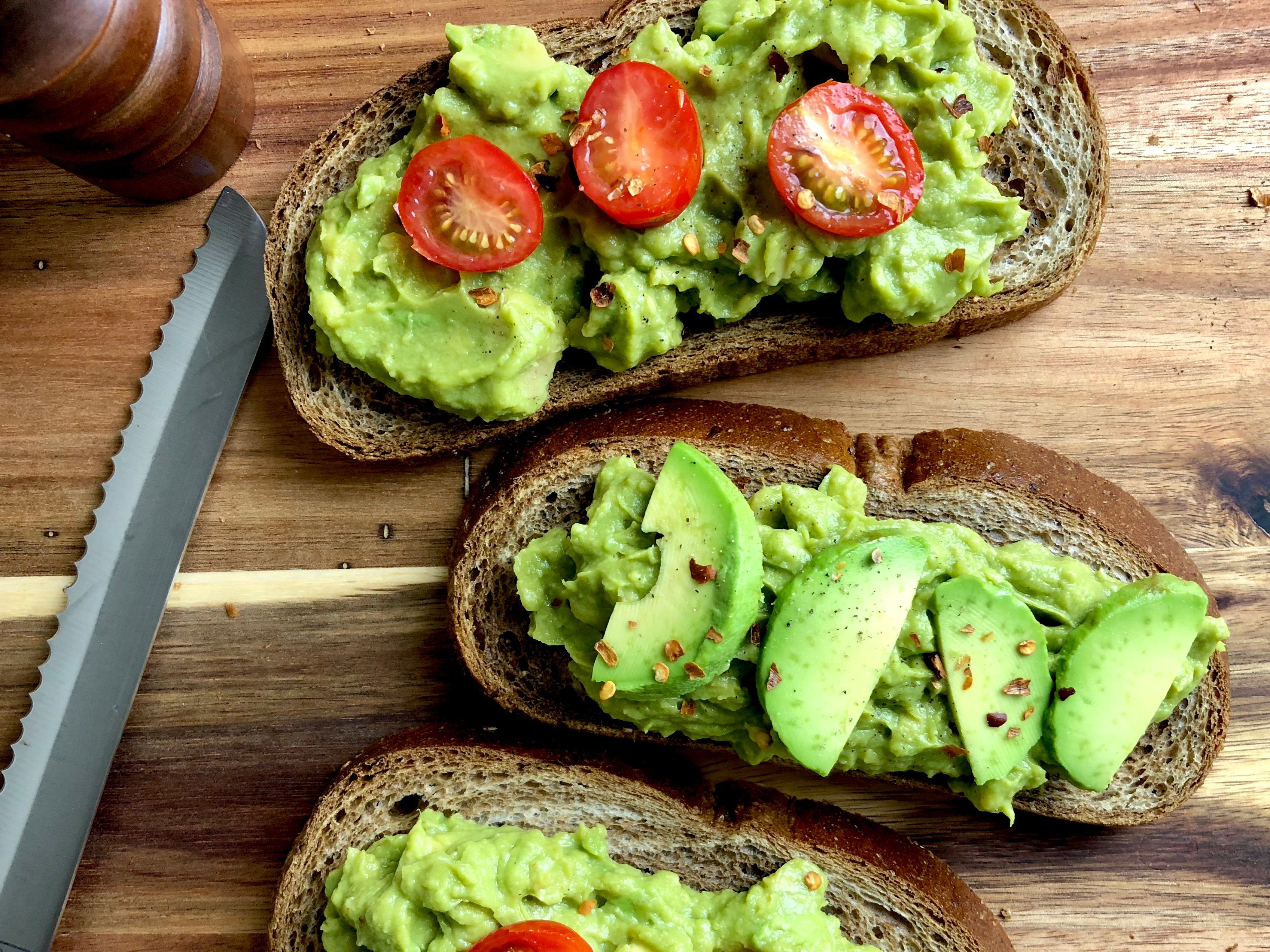 Top view of avocado toast on a wood cutting board