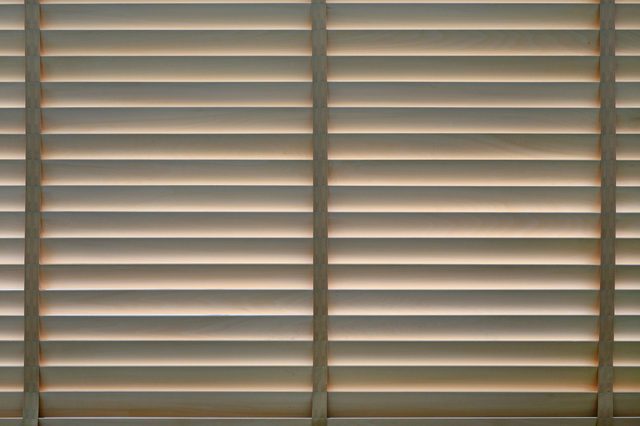 Wood blinds or curtain by the window.
