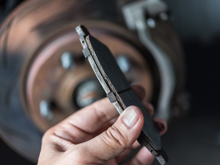 How often should you change your brake pads - Hand holding brake pad