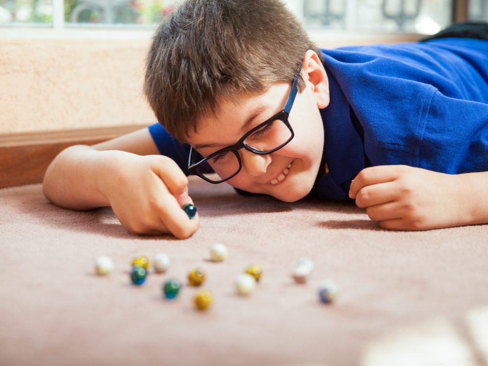 Young boy playing marbles