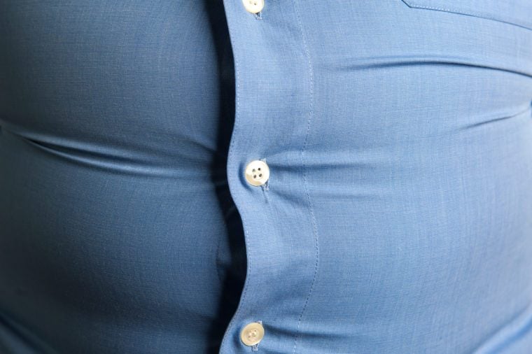 Overweight man wearing tight button-down shirt