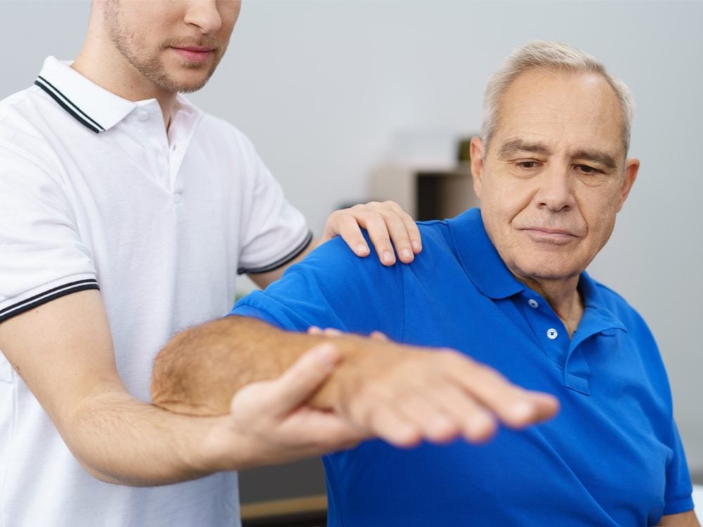 Man holding out arm during physiotherapy