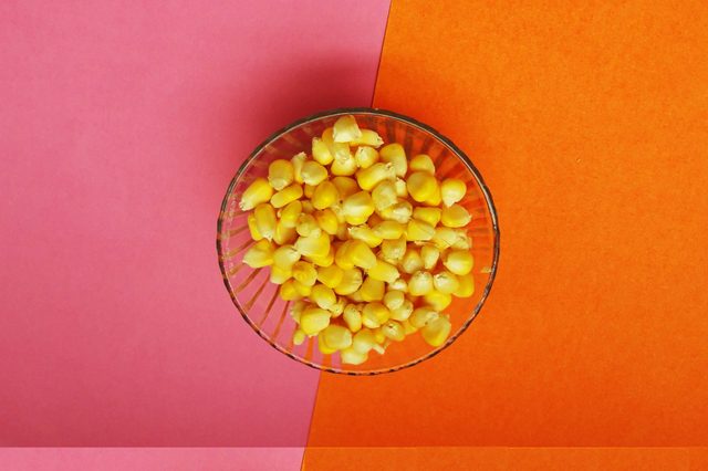 healthy raw sweet corn isolated on color background