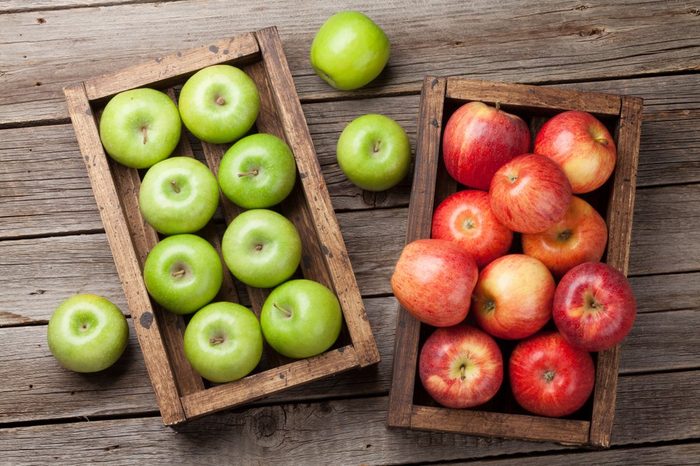Ripe green and red apples in wooden box. Top view