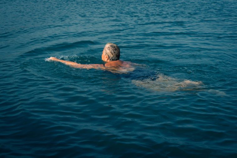 Senior man swimming in lake