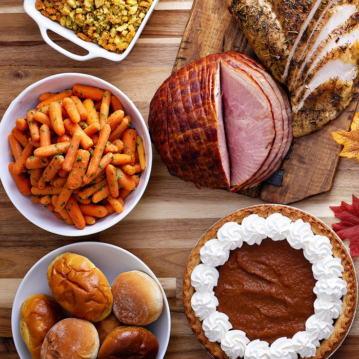Thanksgiving table with roasted turkey, sliced ham and side dishes; Shutterstock ID 1178474017; Job (TFH, TOH, RD, BNB, CWM, CM): TOH