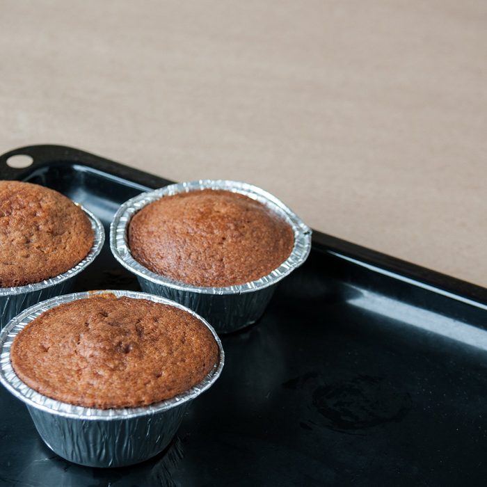 genius holiday tips - Fresh cupcakes are on a black pan on the table, cookie sheet, cupcake