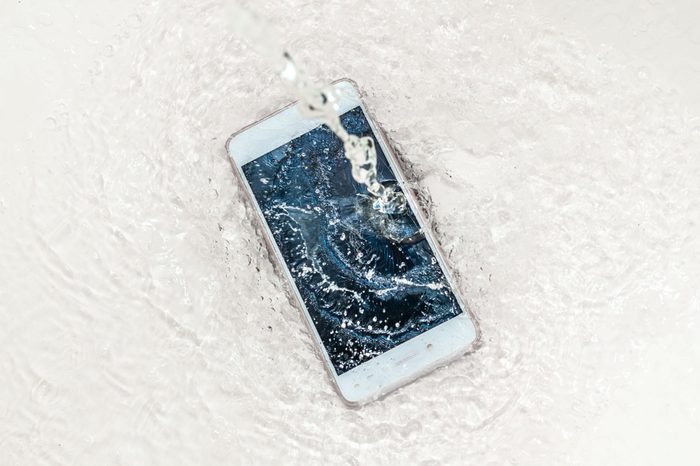 Phone in the water. Concept broken phone. Smartphone repair concept