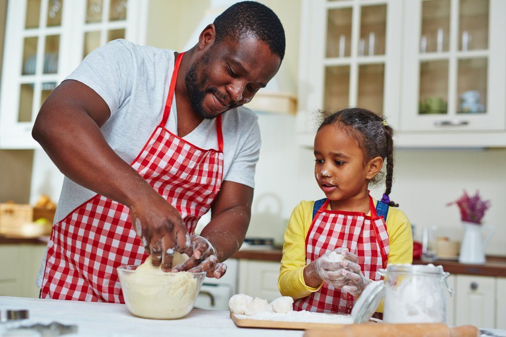 Young man and his daughter making pastry in the kitchen