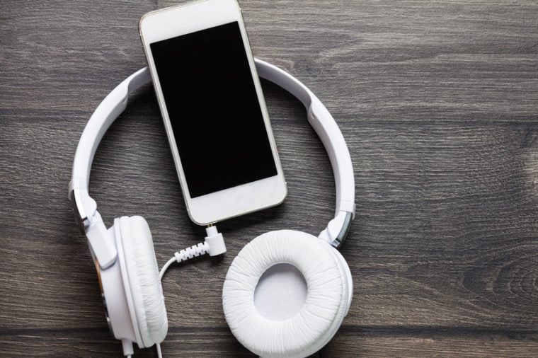 White headphones connected to white smartphone