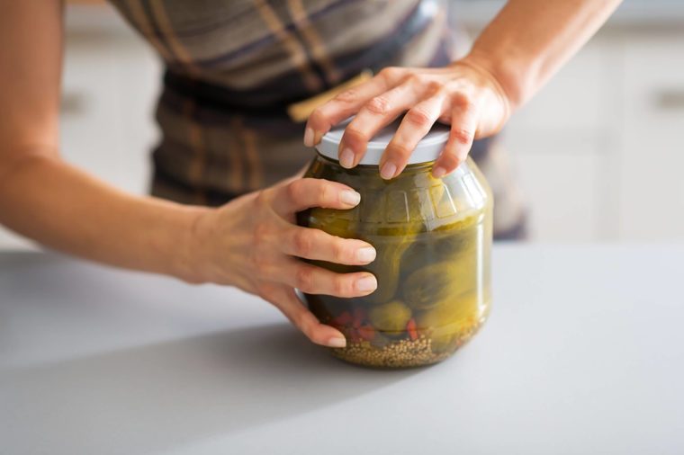 Housewife opening jar of pickles