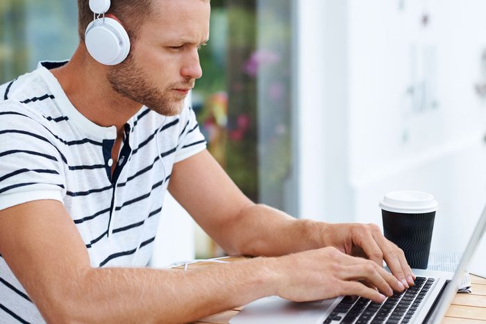 man wearing headphones on computer