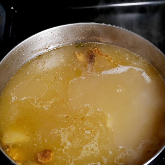holiday cooking tips - Pot of simmering pork stock on the stove with a skim of fat on the surface, and steam rising from it.; Shutterstock ID 758373580; Job (TFH, TOH, RD, BNB, CWM, CM): TOH