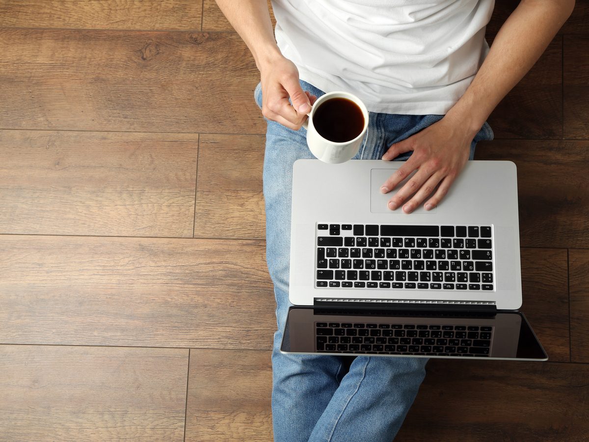 Man on laptop while drinking coffee