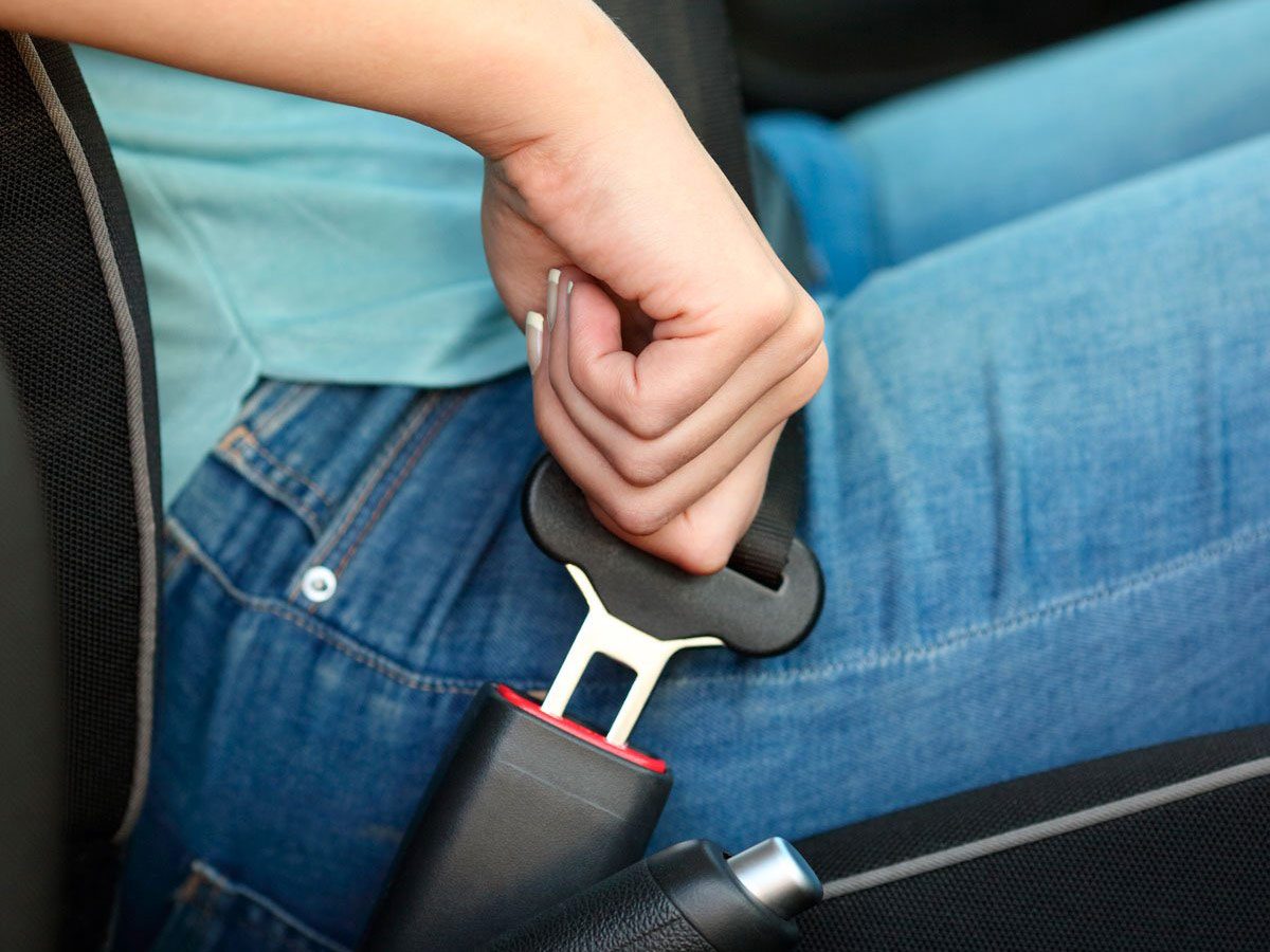 Woman putting on seatbelt
