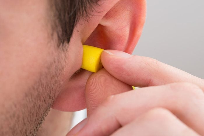 Close-up Of Person Ear With Yellow Earplug