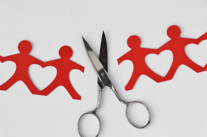Broken people paper chain with scissors on white background - Broken relationships concept