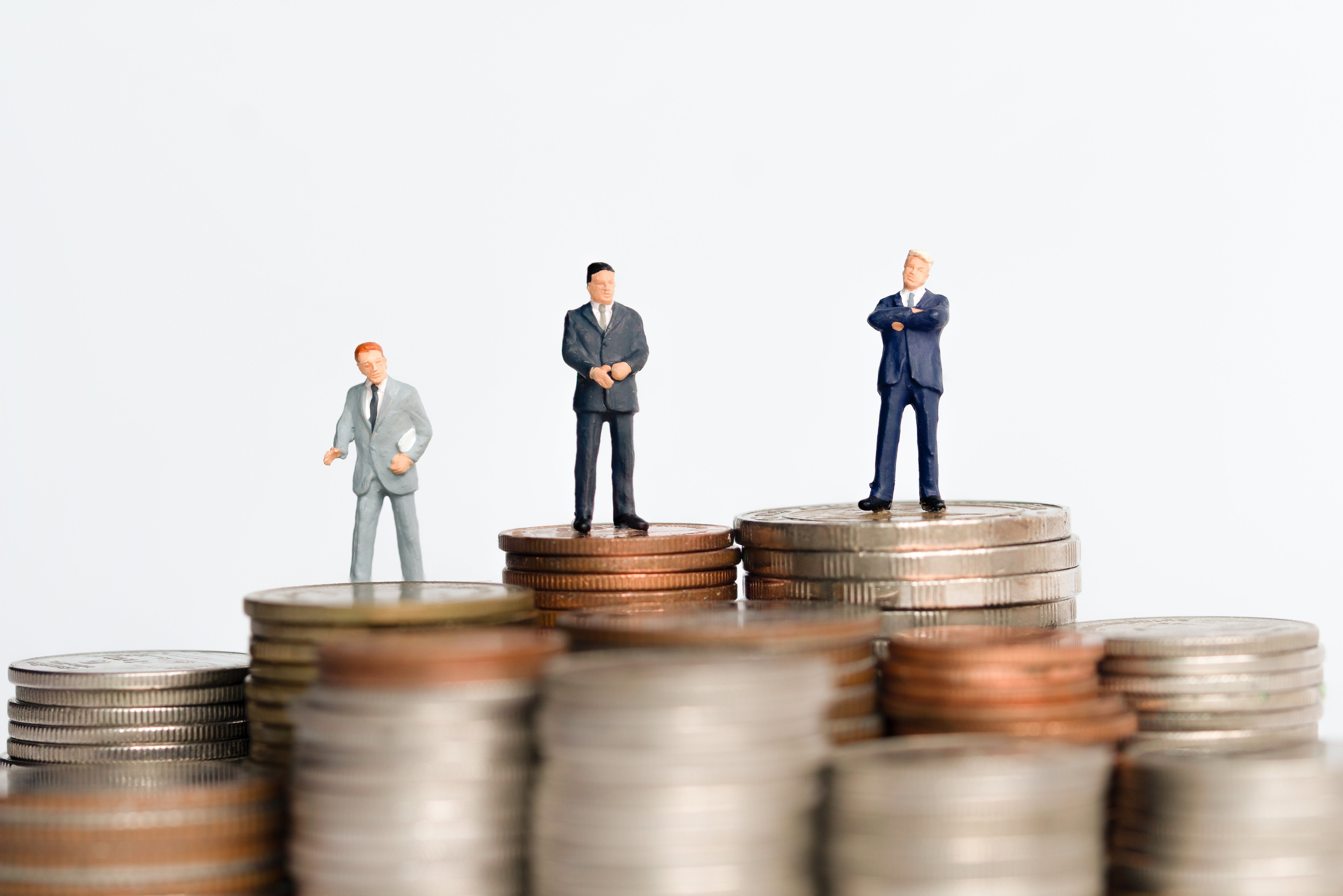 Mini figure people : Small businessman standing on step or stack coins with blurred background for financial concept