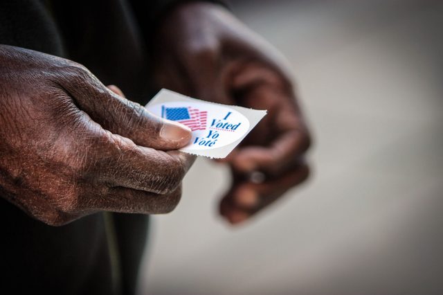 An elderly African American man holds his I voted sticker after he cast his ballot in Washington, DC.