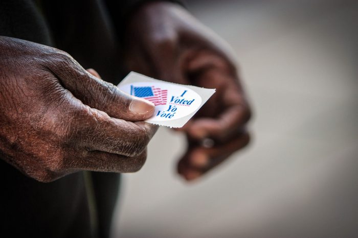 An elderly African American man holds his “I voted” sticker after he cast his ballot in Washington, DC.