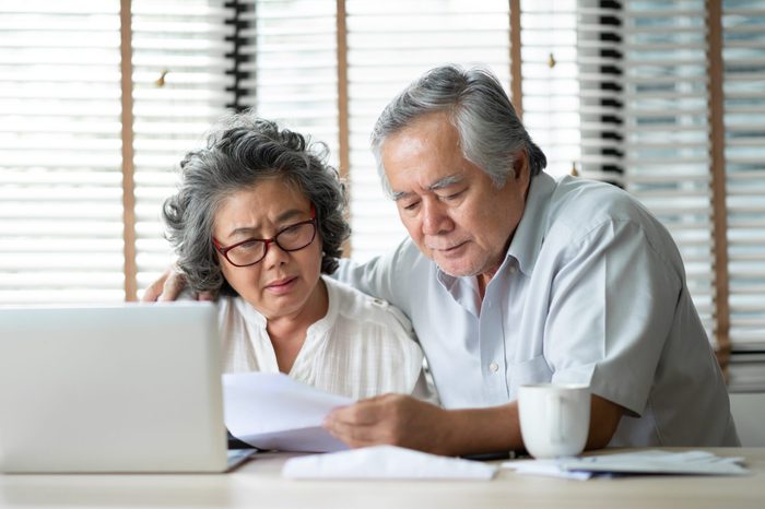 Stressed Asian Senior Couple calculate their monthly expense with laptop computer. Debts, Saving, Financials with Retirement.