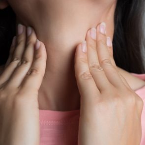 Sore Throat. Closeup Of Beautiful Young Woman Hand Touching Her Ill Neck. Healthcare and medical concept.