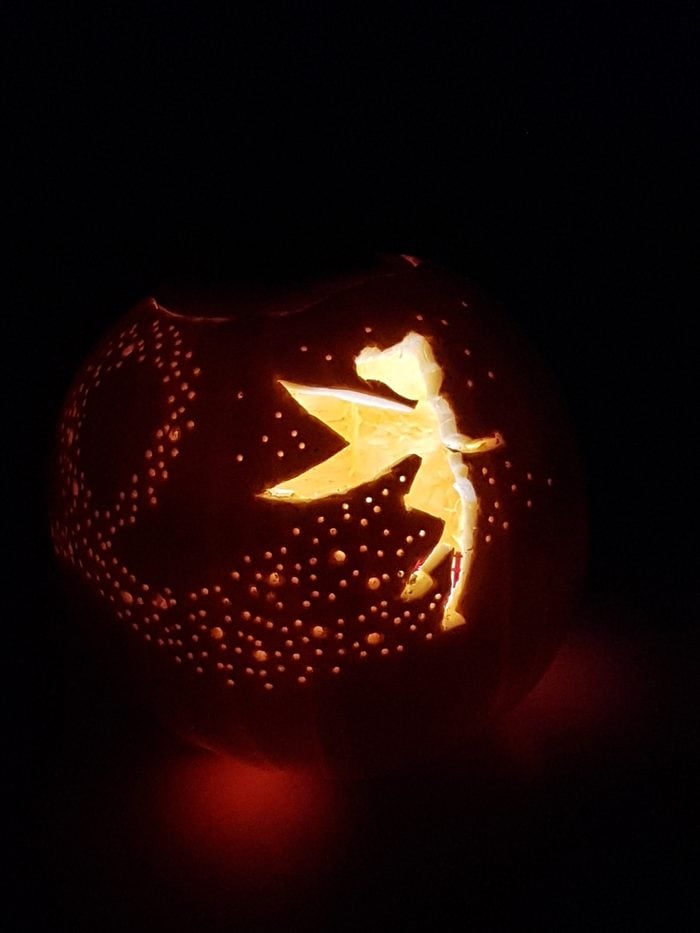 Pumpkin with Tinkerbell carved on the front and a candle inside
