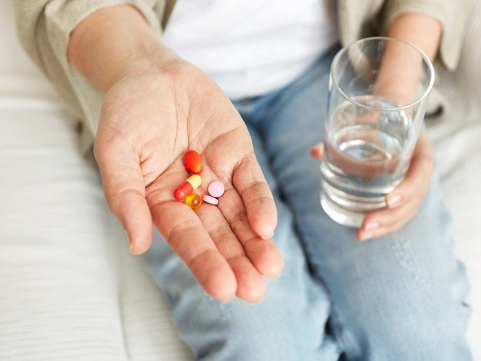 How to live to 100 - person taking pills with water