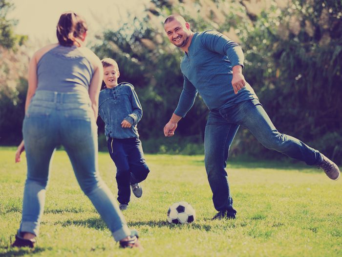 Family of three playing soccer