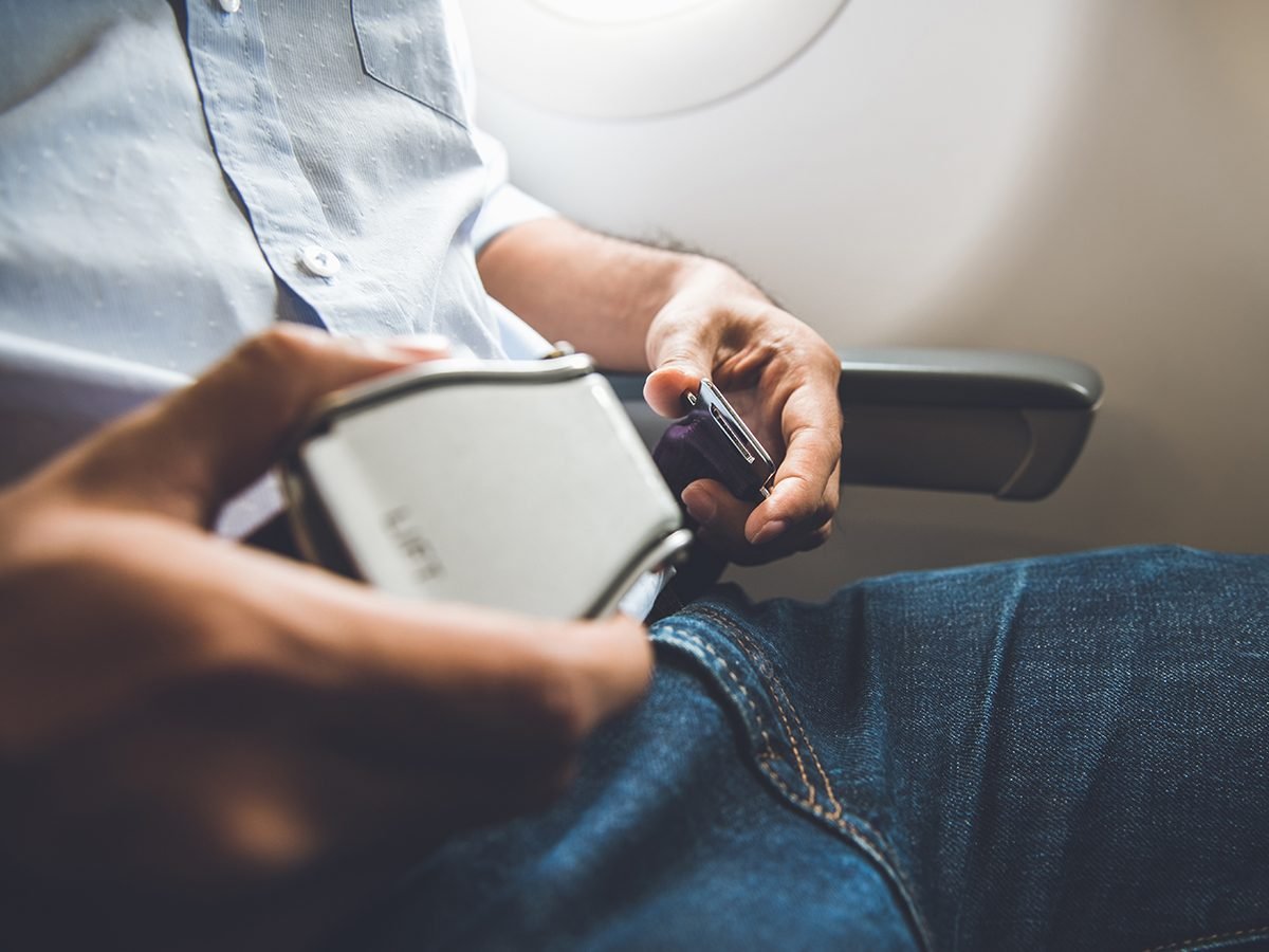 Man buckling seatbelt on airplane