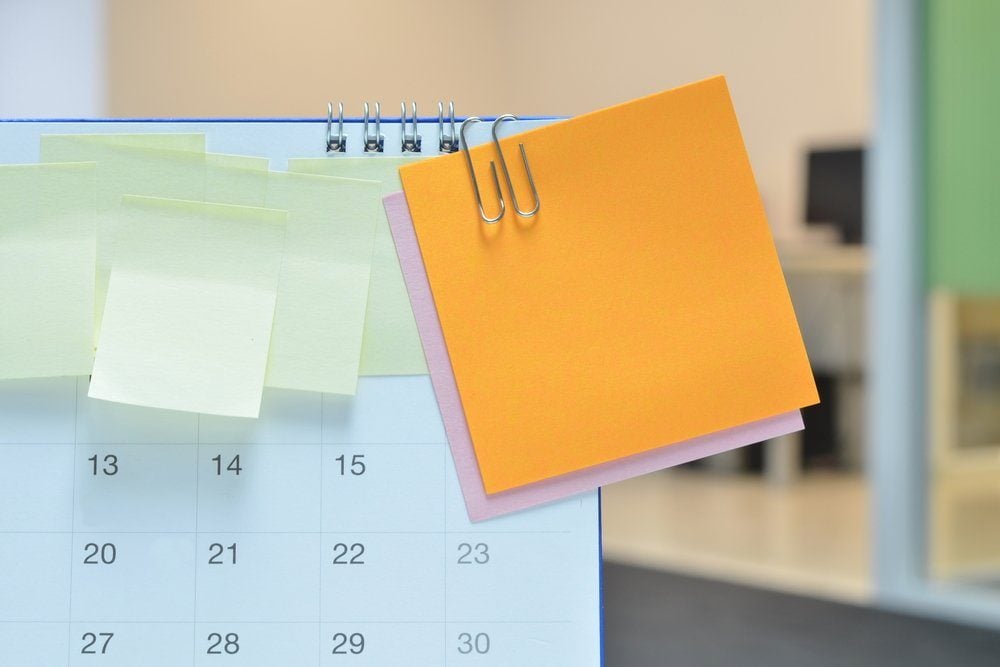 Paper notes on calendar at business office with copy space for text,office supplies