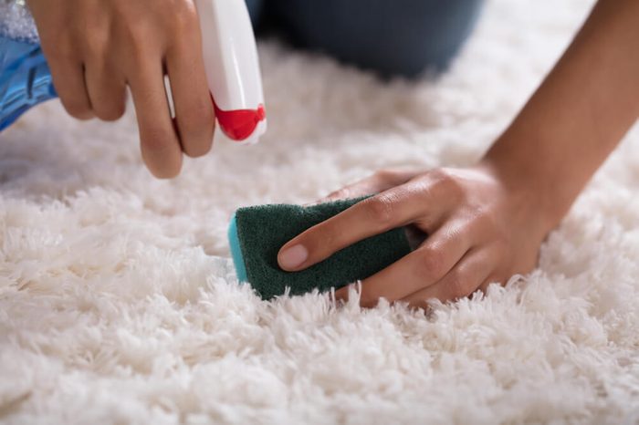 Close-up Of A Person's Hand Cleaning Carpet With Sponge