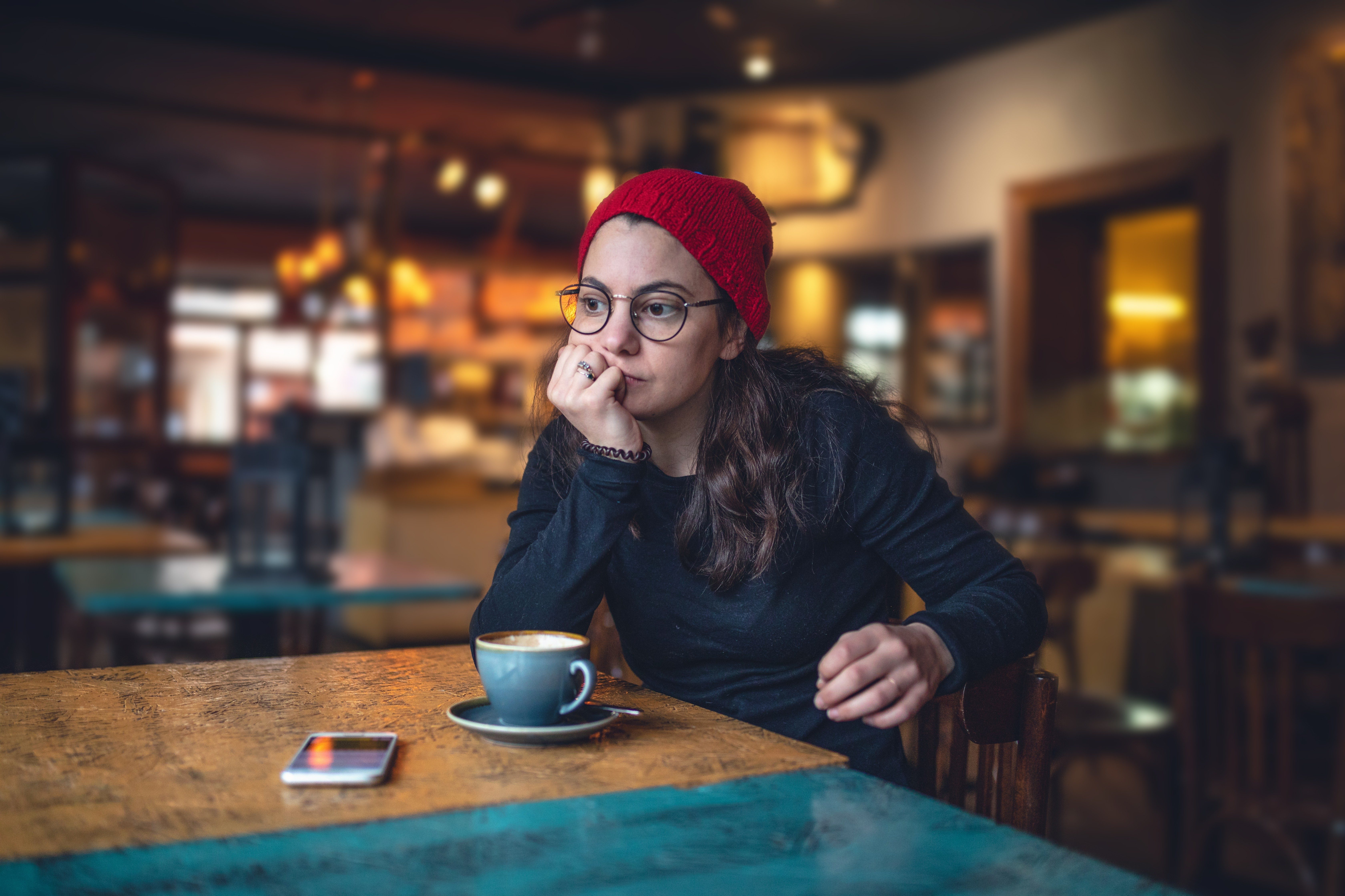 lonely girl in a coffee shop looking worried