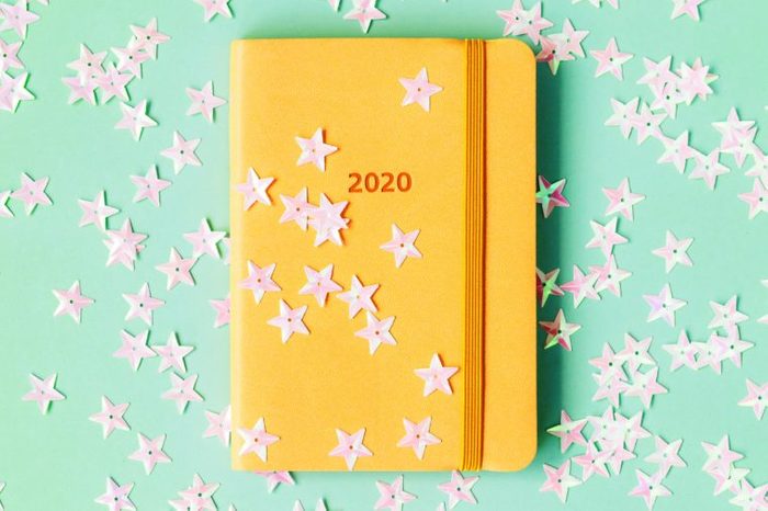 star confetti on yellow notebook on teal background