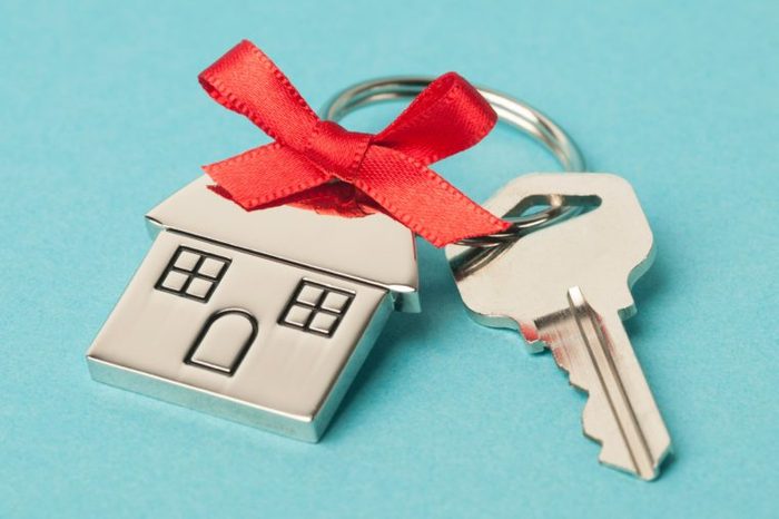 key and house keychain with red bow on aqua background
