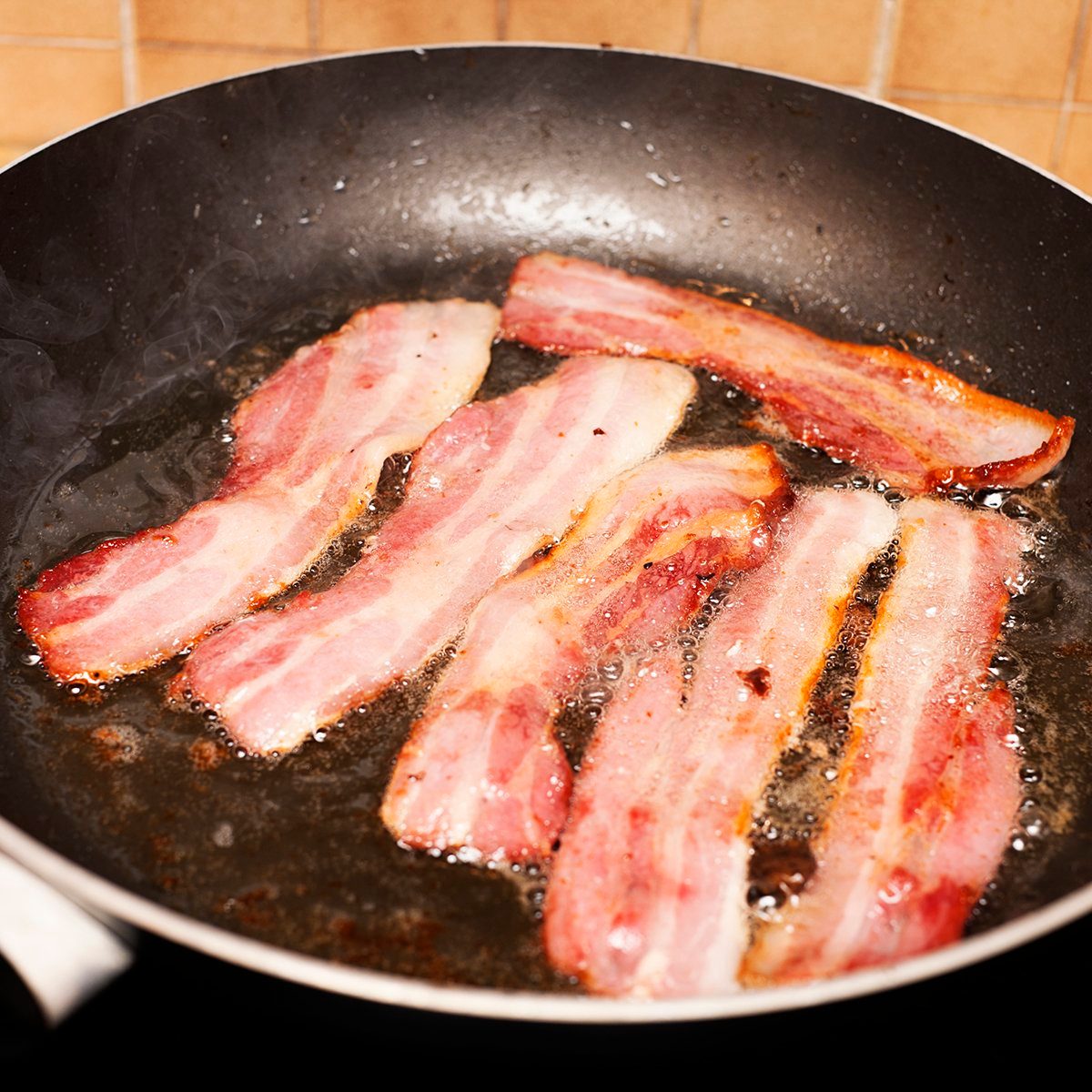 Appetizing frying pan full of sizzling rashers of bacon. Shot with Canon EOS 1Ds Mark III.