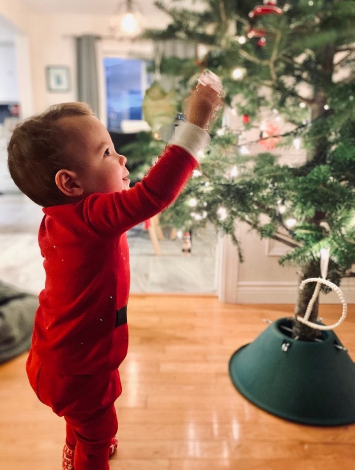 Small boy putting a decoration on a tree