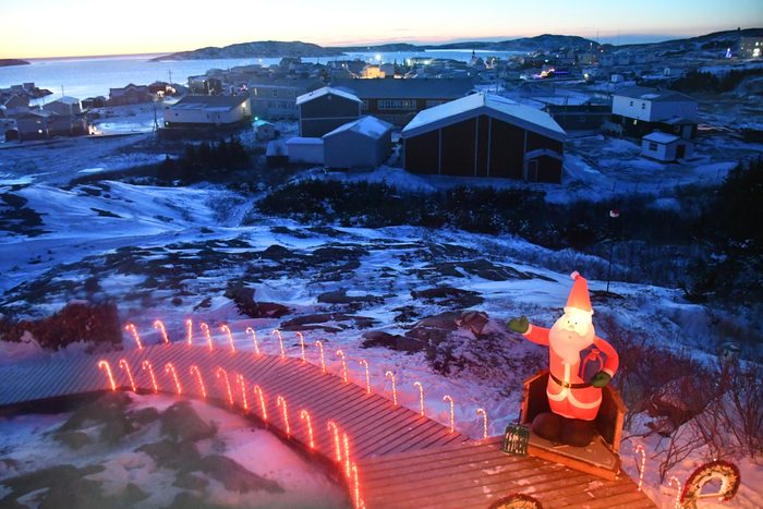Plastic Santa figure looking out over the harbour in Cote Nord, Quebec