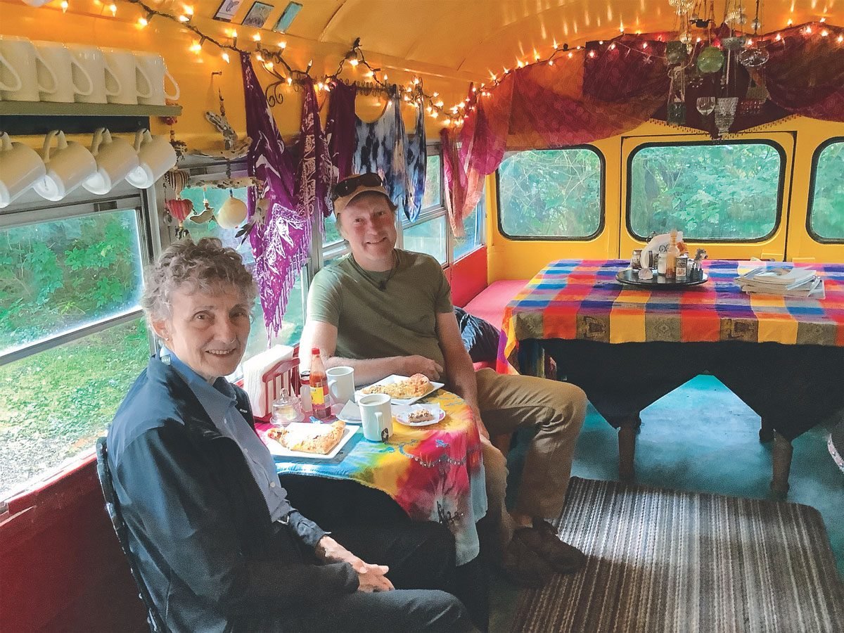 Penny and Brett enjoying coffee and treats at the Moon Over Naikoon Bakery—a converted school bus parked off the road in the woods