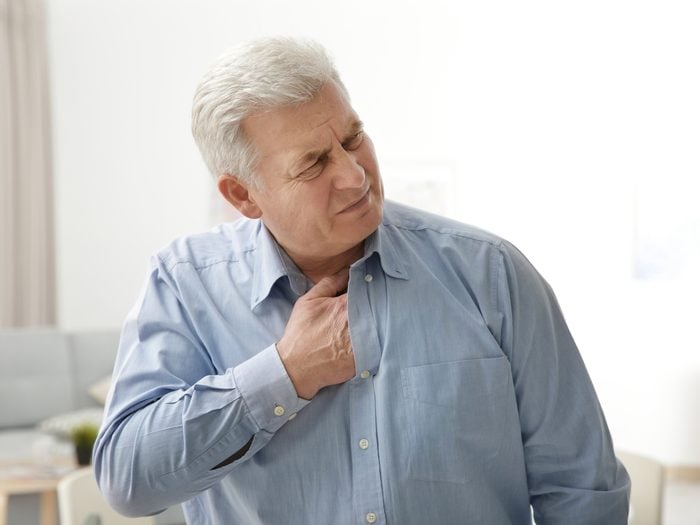 heart attack symptoms - Man clutching chest