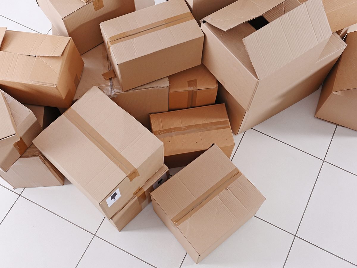 House move concept. Carton boxes on tile floor background