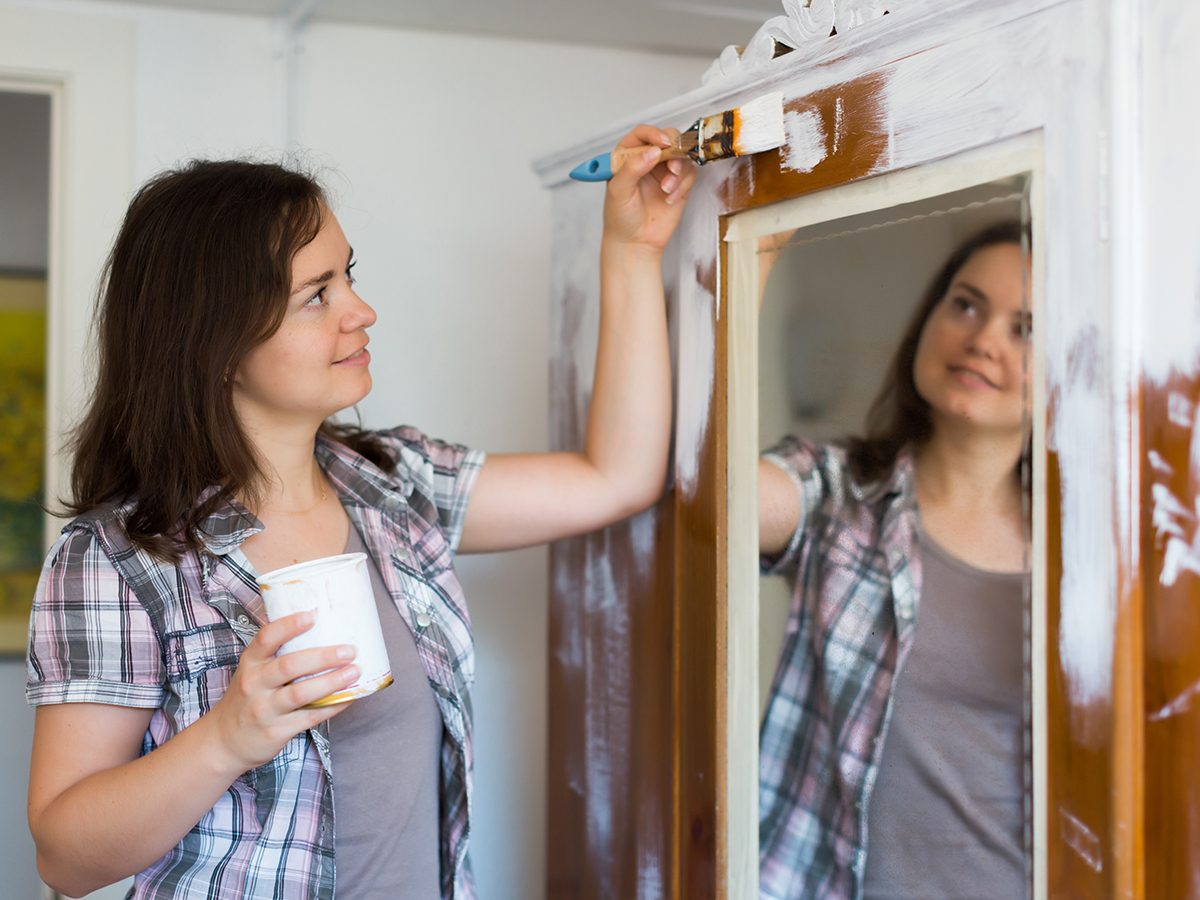 Young woman paints closet and makes repairs in the apartment ..