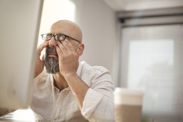 Signs you need new glasses - Senior businessman rubbing his tired eyes